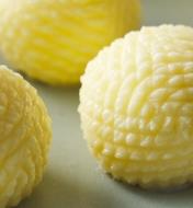 Three decorative, ridged balls of butter.