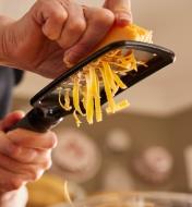 Using the ultra-coarse paddle grater to grate cheddar cheese