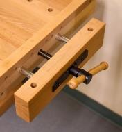 An open vise on the end of a workbench