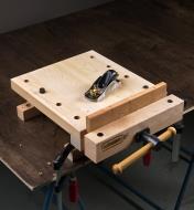A board secured in the vise of a workstation.