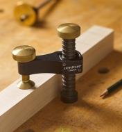 The Veritas Surface Clamp clamping a piece of wood to a workbench