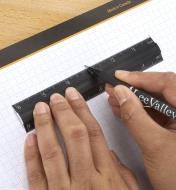 Personne utilisant une règle d'établi pour marquer une mesure sur un bloc de papier quadrillé Veritas