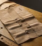 A Leather Tool Roll with some tools lying open on a workbench