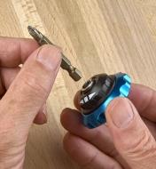 A screwdriver bit being connected to a palm driver