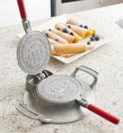 The krumkake and pizzelle iron with open griddle plates showing the embossed design