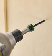 A drill with a magnetic driver bit driving a screw into a wooden board