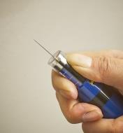 The tip of a stud finder being pulled back to display the needle inside
