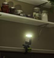 A rechargeable clip light mounted with the clamp base on the edge of a kitchen counter