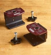 Both sets of steel dovetail fittings from a movable-mount marquetry set arranged on a workbench