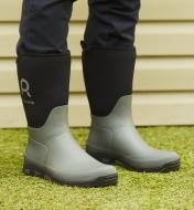 A person wearing garden boots while standing on grass