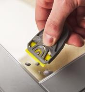 Removing splatters from tile using a razor blade in a holder