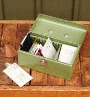 A seed keeper box sits open on a potting bench with various seed packets stored inside it
