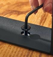 Tightening a bolt on a table leg using a hex key