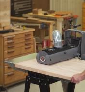 A wide board being fed through the 19-38 drum sander