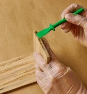 Applying glue on the ends of a piece of wood with a glue spreader