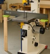 A board supporting an infeed/outfeed support at the end of an extended fence on a bandsaw