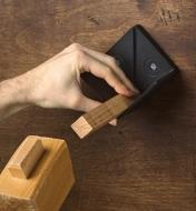 Tapping a wood block held in the center marker with a mallet to mark the center