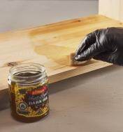 Applying Odie’s dark oil to wood using a sponge