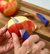 Using the peeling knife to peel the skin off an apple