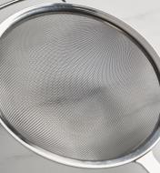 A close-up view of the sieve/sifter’s fine mesh