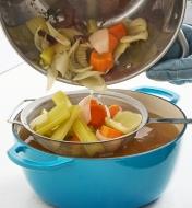 Straining vegetables from broth through a mesh sifter