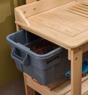 The cypress potting table’s reservoir sticking out from under the table top