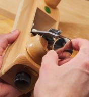 A woodworker uses the Primus mechanism on an E.C. Emmerich Primus smooth plane to adjust the blade