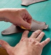 Rubbing leather with a small piece of sandpaper