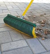 A Fusselschreck Outdoor Broom is used to sweep a patio