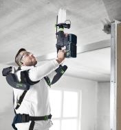 Drilling into a ceiling using a hammer drill with a dust extraction adapter attached