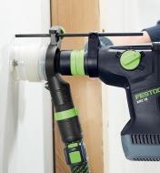 Drilling into drywall using a hammer drill with a dust extraction adapter attached