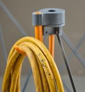 A close-up view of an extension cord hung on a hook mounted on the leg cap of a Bora Centipede table