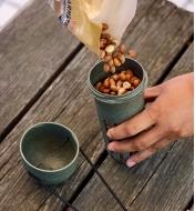 Filling the peanut bird feeder with peanuts