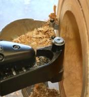 A close-up view of a Bowlsaver Max4 cutter penetrating a wooden blank on a turntable-guided path