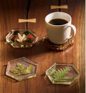 Four decorative epoxy table coasters arranged on a table, one with a cup of coffee placed on it