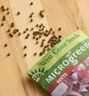 Beet microgreen seeds scattered on a wood surface next to a seed packet