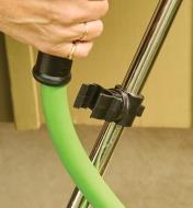 Holding a hose next to the plastic holder on the stainless-steel hose reel cart