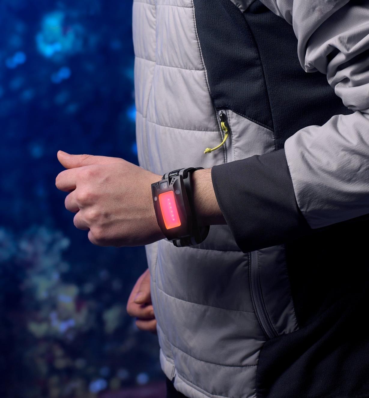 The multi-function LED headlamp is worn on a runner’s wrist