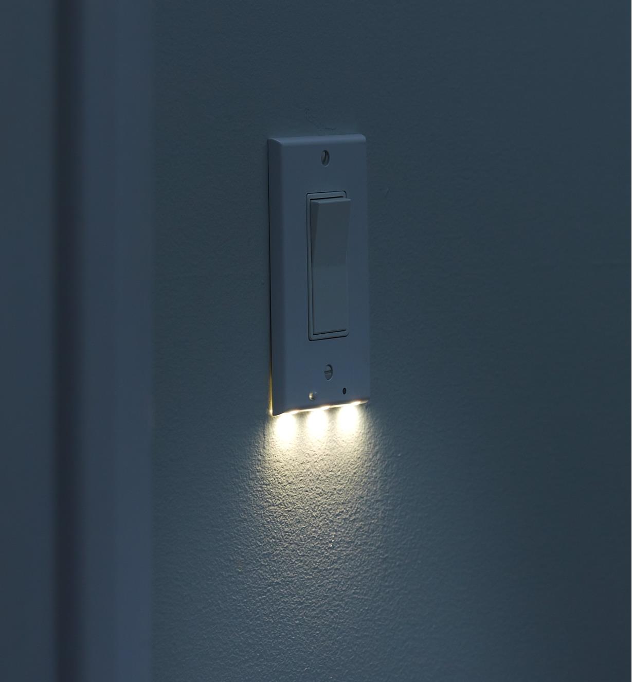 An LED rocker switch cover plate mounted on a wall, giving gentle, diffused illumination at night.