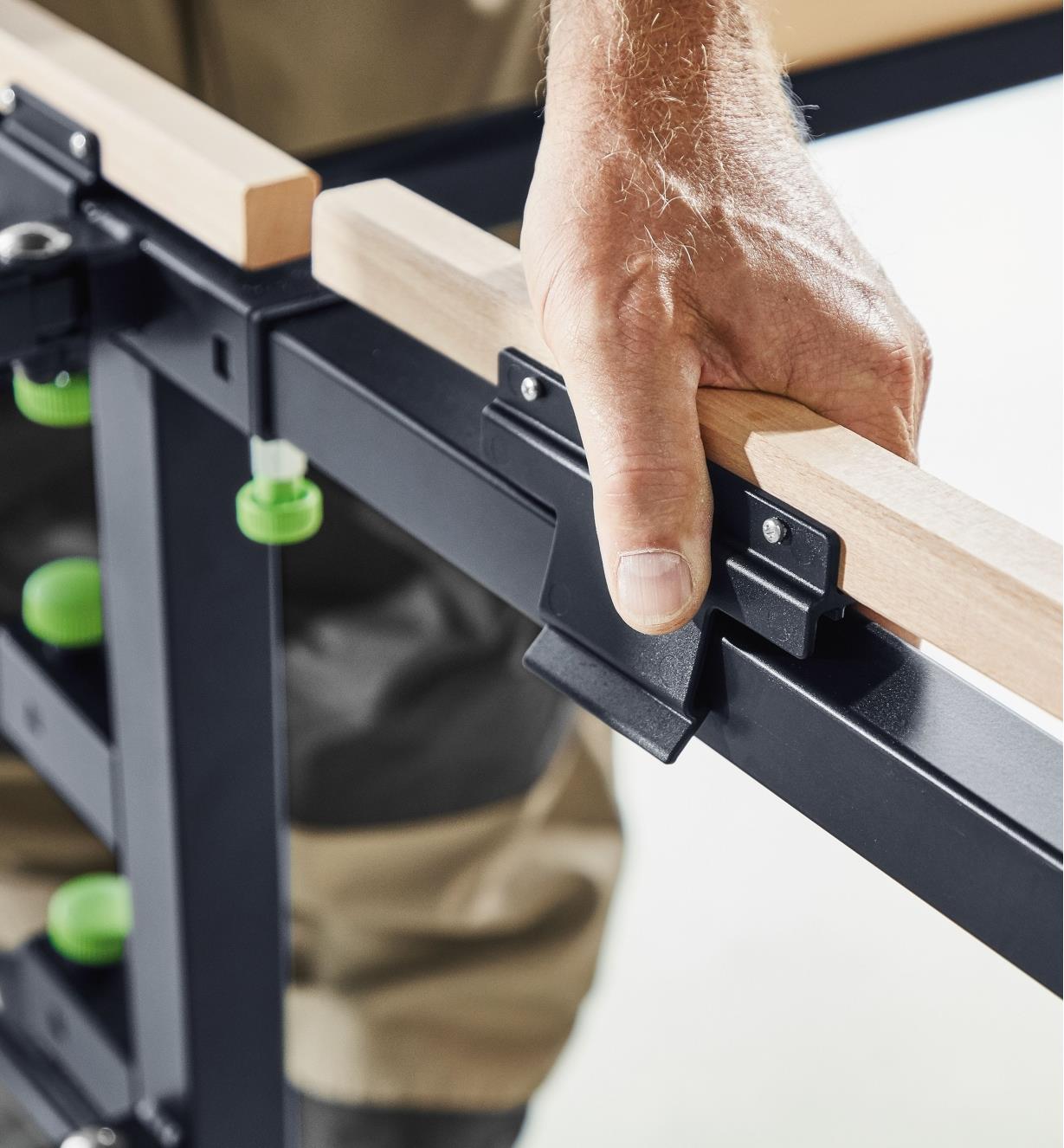 Clipping a wooden support onto the frame of the mobile sawing table