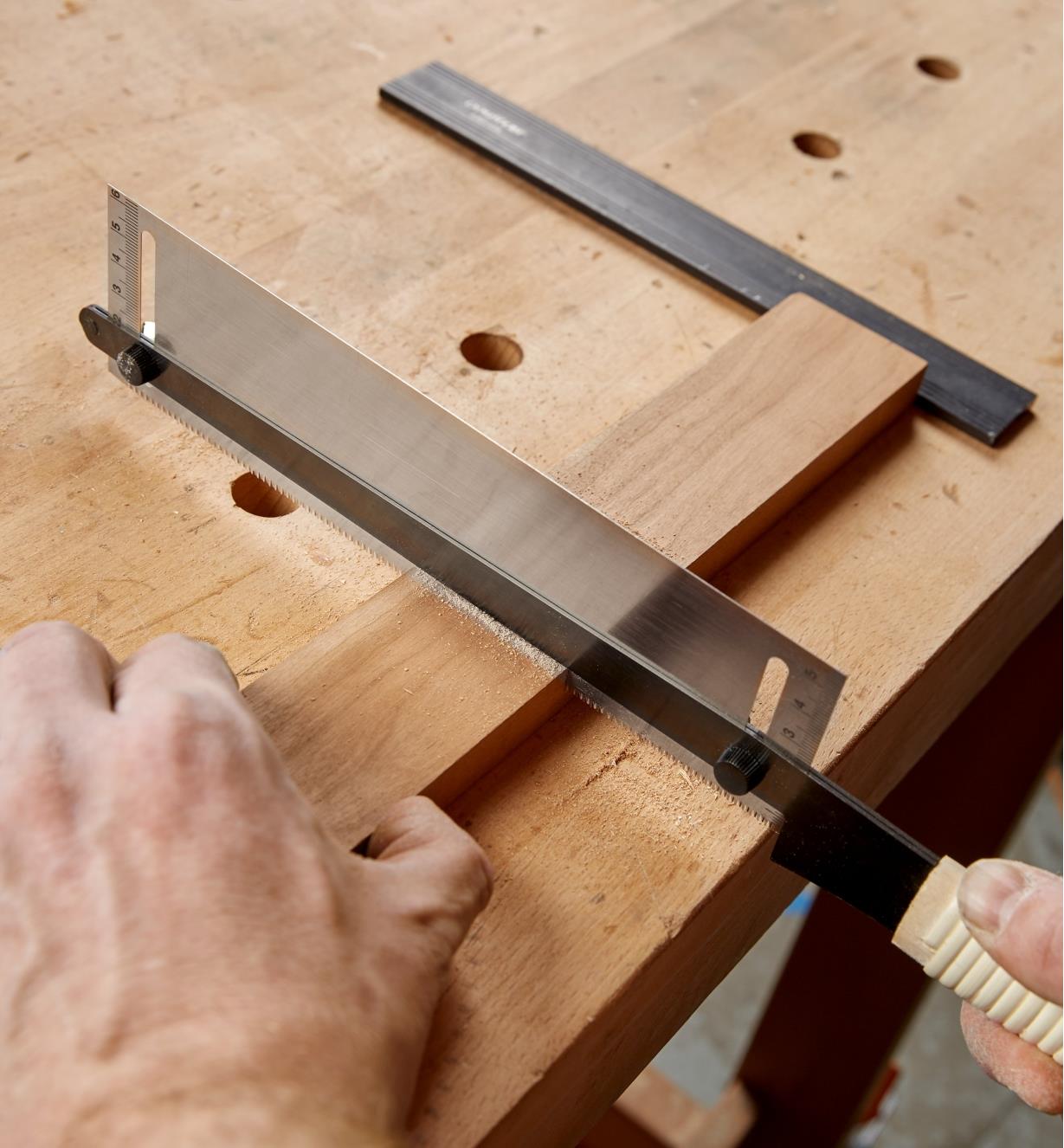 An adjustable-depth dozuki being used to make a cut in a thin piece of wood