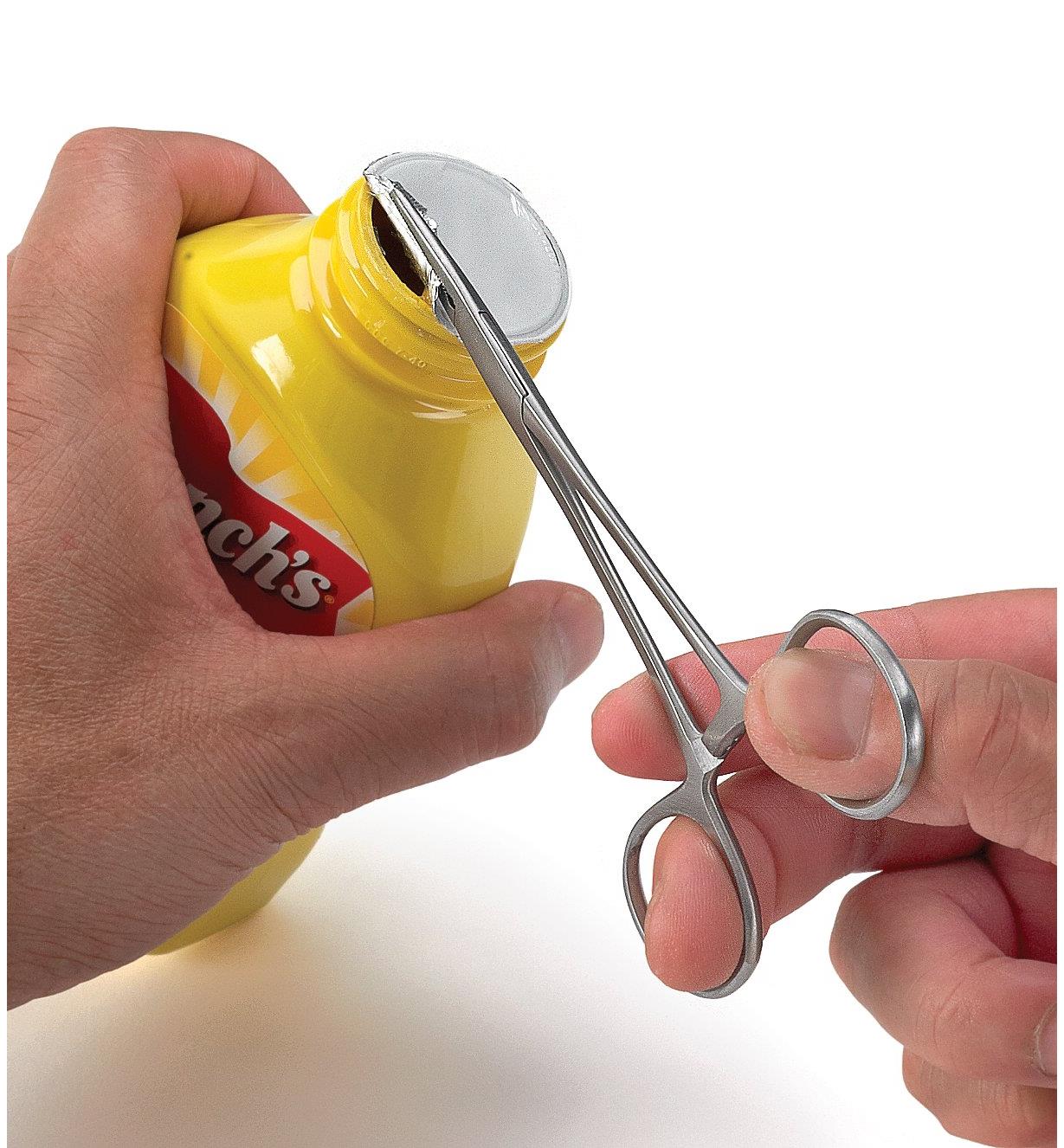 Using seal removal pliers to remove a seal from a mustard container 