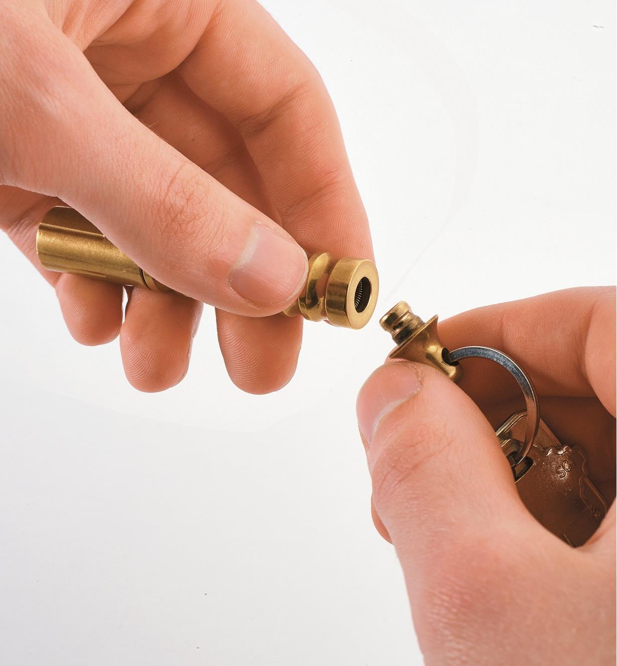 Detaching the brass flashlight from the key ring