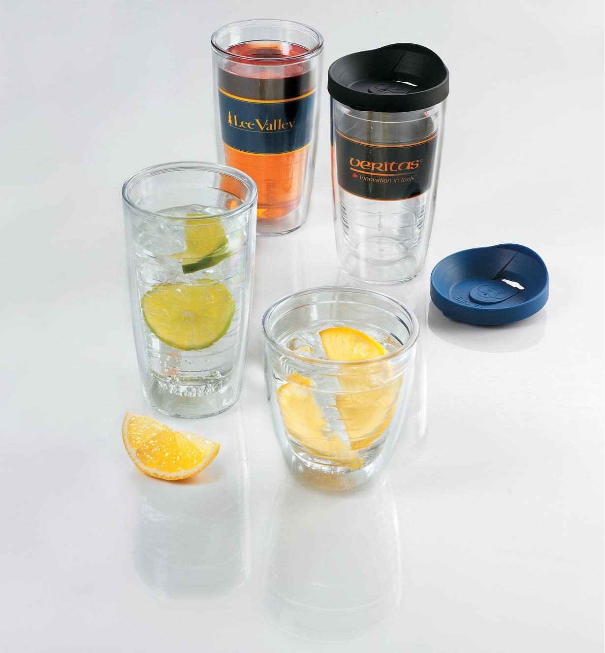 Four Tumblers filled with beverages and lemon and lime wedges