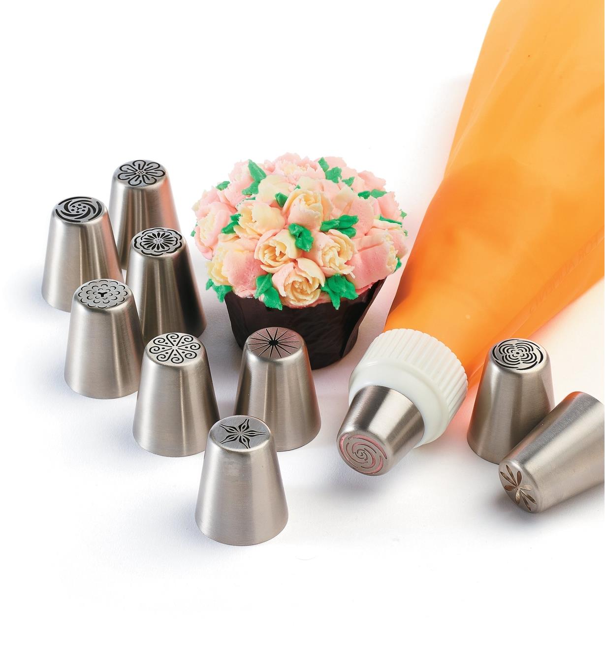Set of 10 large piping tips sitting next to a decorated cupcake, with one tip attached to a piping bag, sold separately