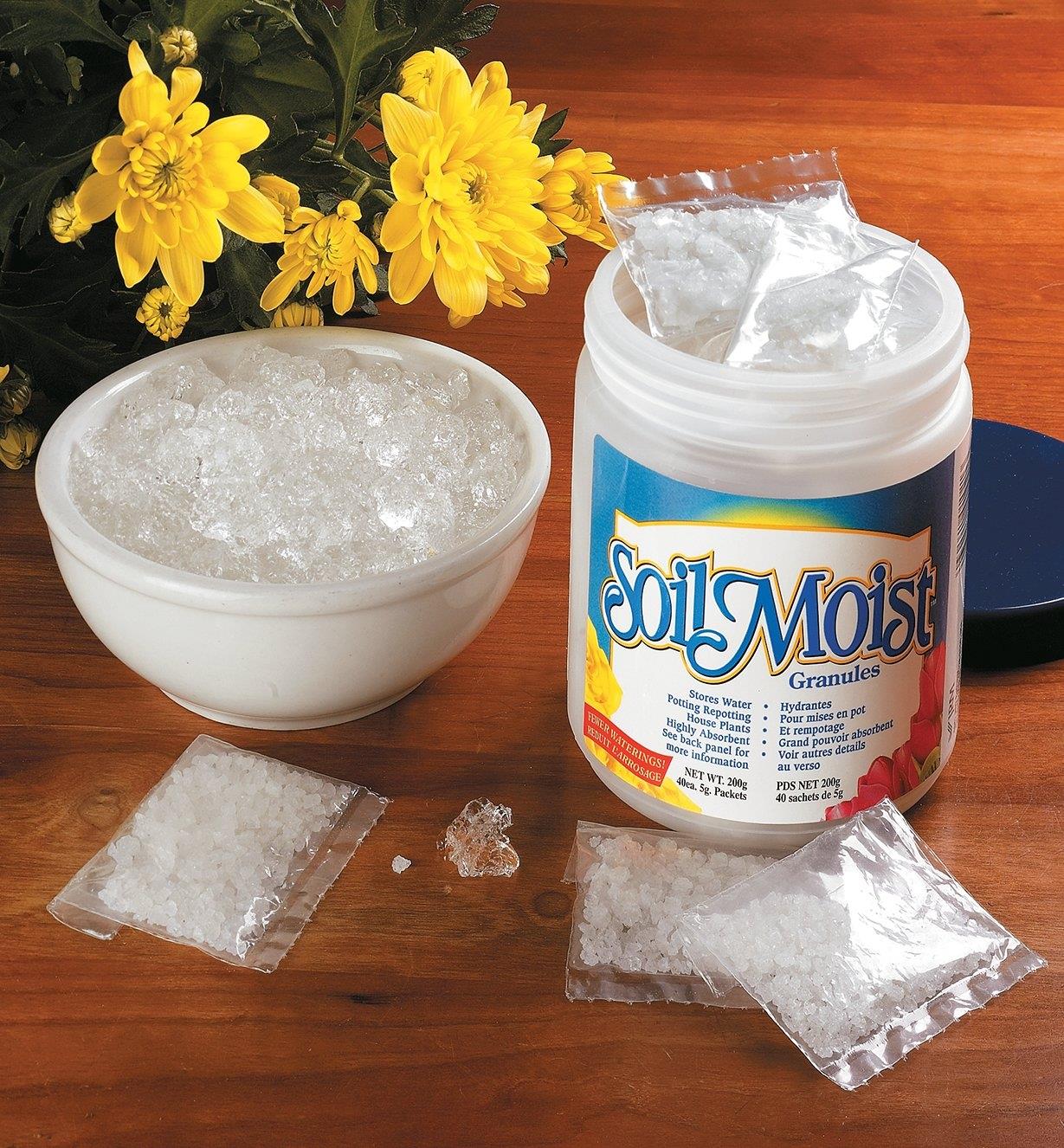 A container of Soil Moist packets beside a bowl of expanded crystals
