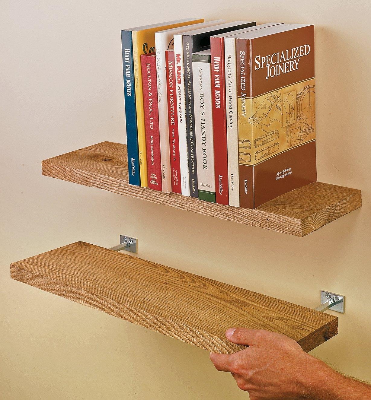 Two pairs of blind shelf supports installed in wooden shelves and mounted to a wall
