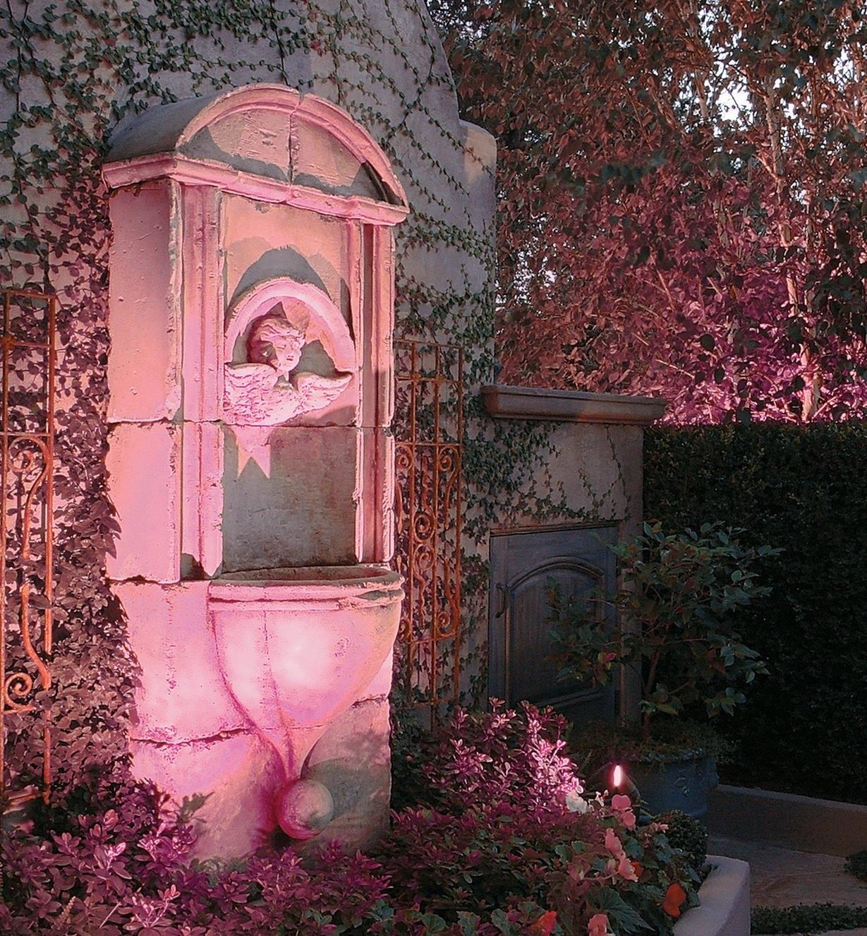 Color-controlled LED (RGB) landscape light installed by a garden fountain