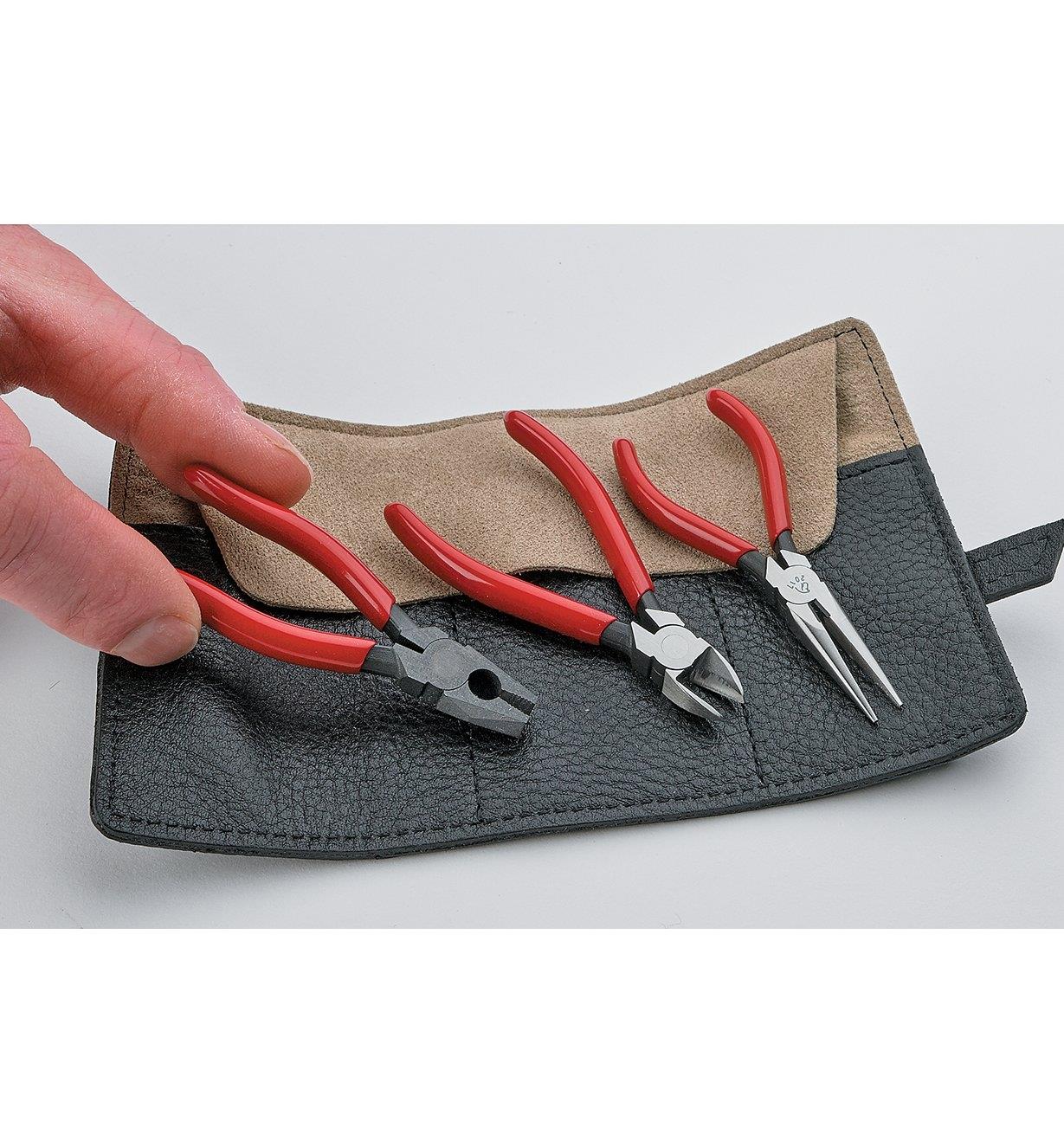 Three Chiisai pliers sitting on top of the included tool roll