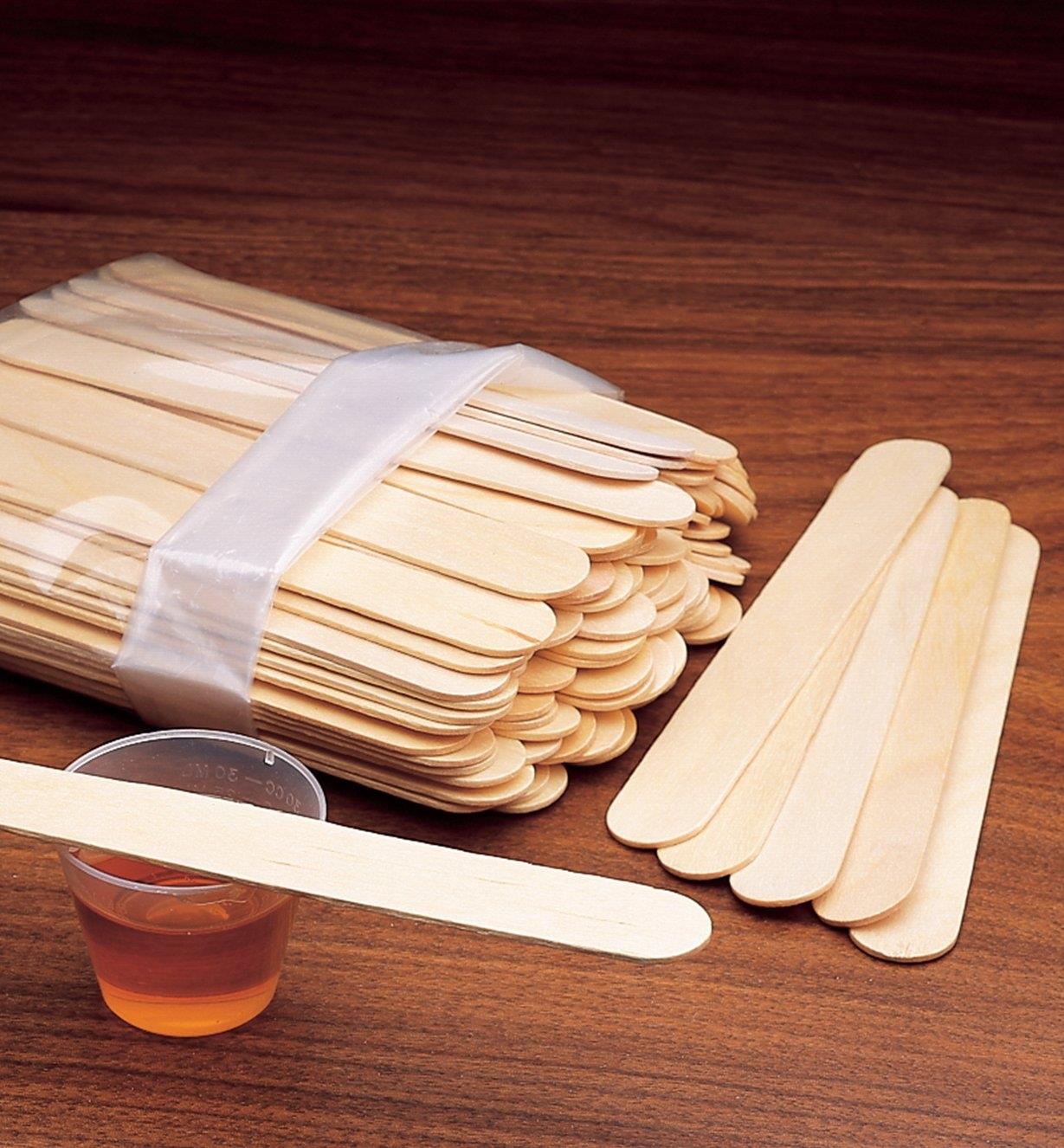 Package of Tongue Depressors on a table with a small cup of stain